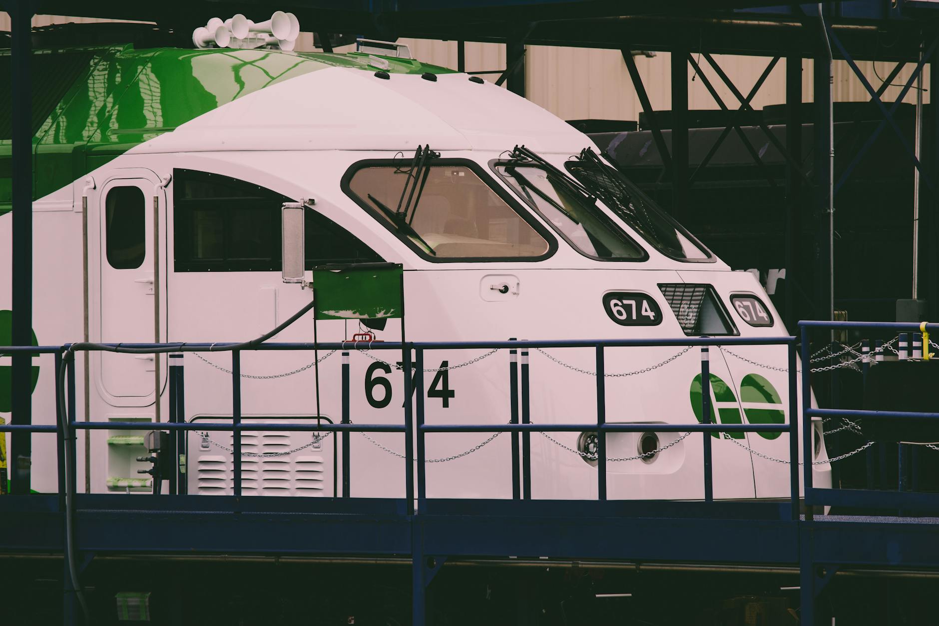 Close-up of a green and white train at a station, showcasing transportation infrastructure.