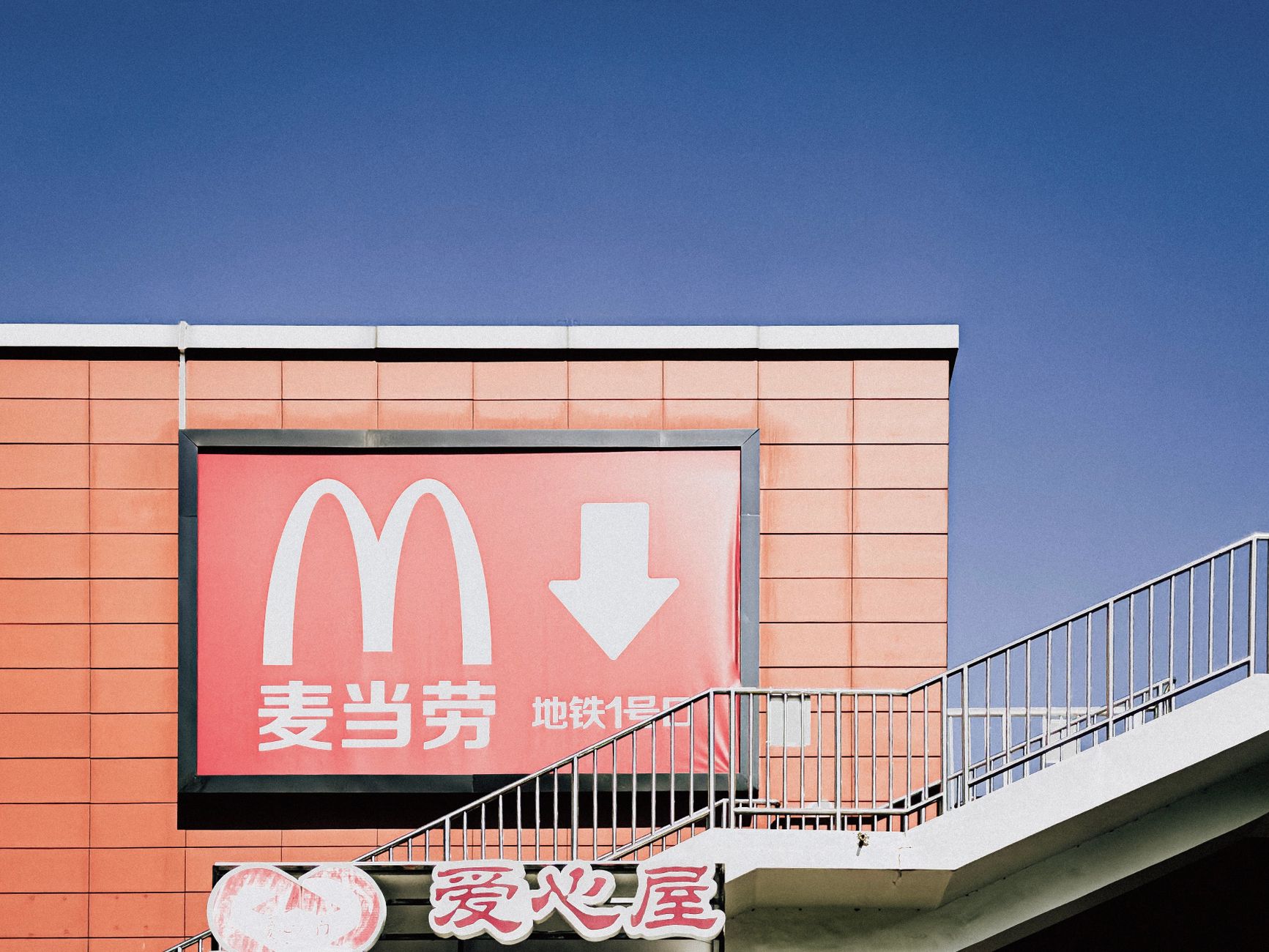 Bright McDonald's advertisement with iconic branding on urban building exterior.