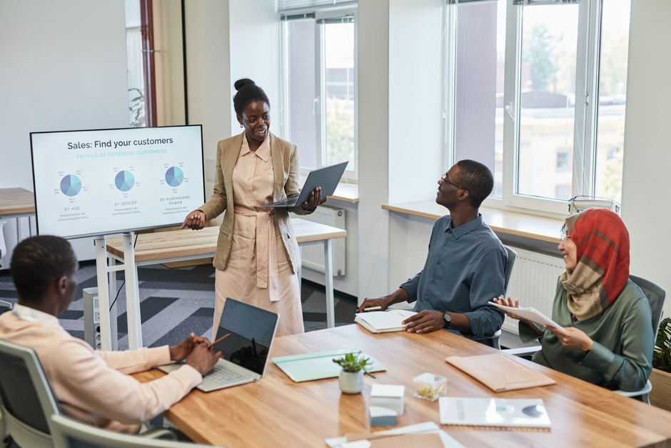Digital marketing agency team reviewing AI search audit charts and competitor benchmark presentation in conference room