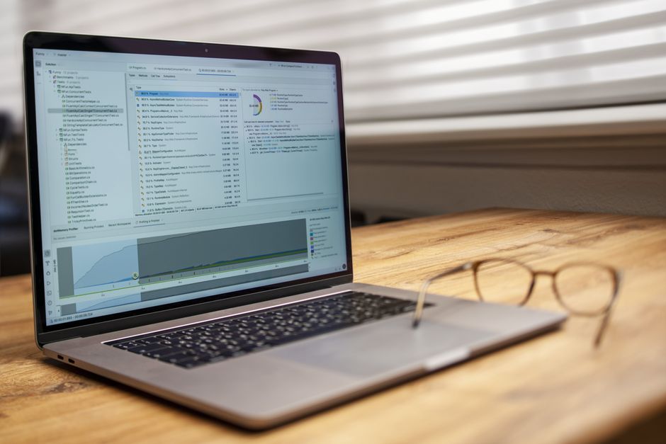 Modern laptop on a wooden desk displaying analytical software with eyeglasses nearby