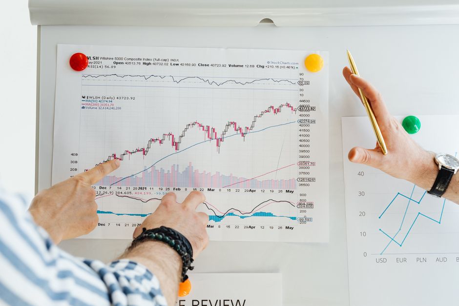 Two professionals analyze stock market graphs with a focus on finance and data trends