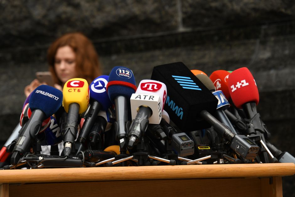 Various microphones setup at a press conference representing digital PR, media relations, and press citations